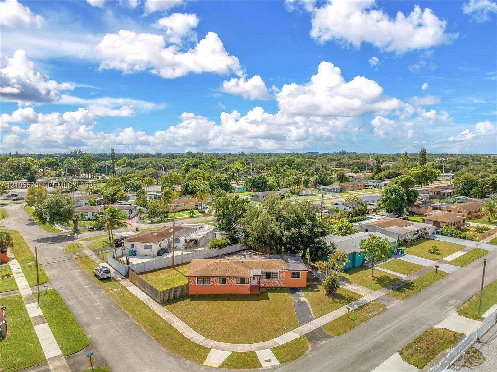 1750 NW 185th Street, Miami Gardens, FL 33056 Corner lot residence featuring a paved driveway, exterior stucco finish, and a shingle roof