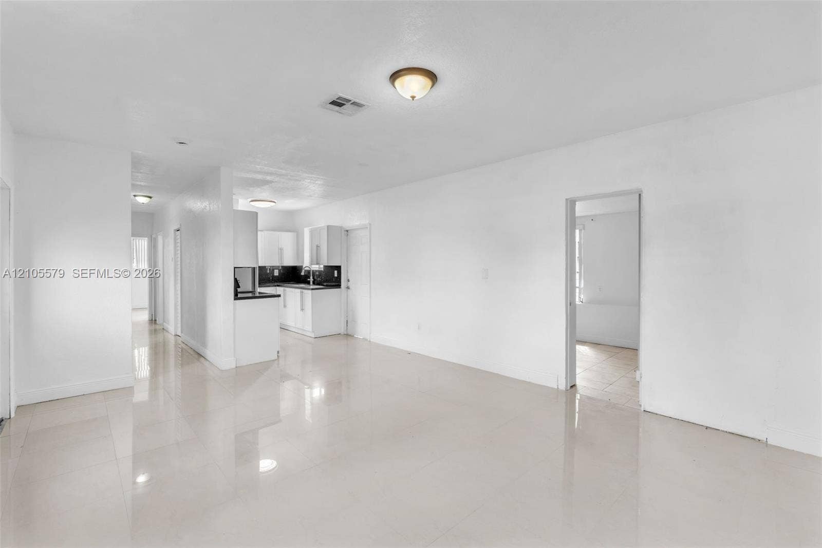 1750 NW 185th Street, Miami Gardens, FL 33056 Interior space featuring neutral wall tones, large-format tile flooring, recessed and flush-mount ceiling lighting, and kitchen cabinetry with contrasting countertops