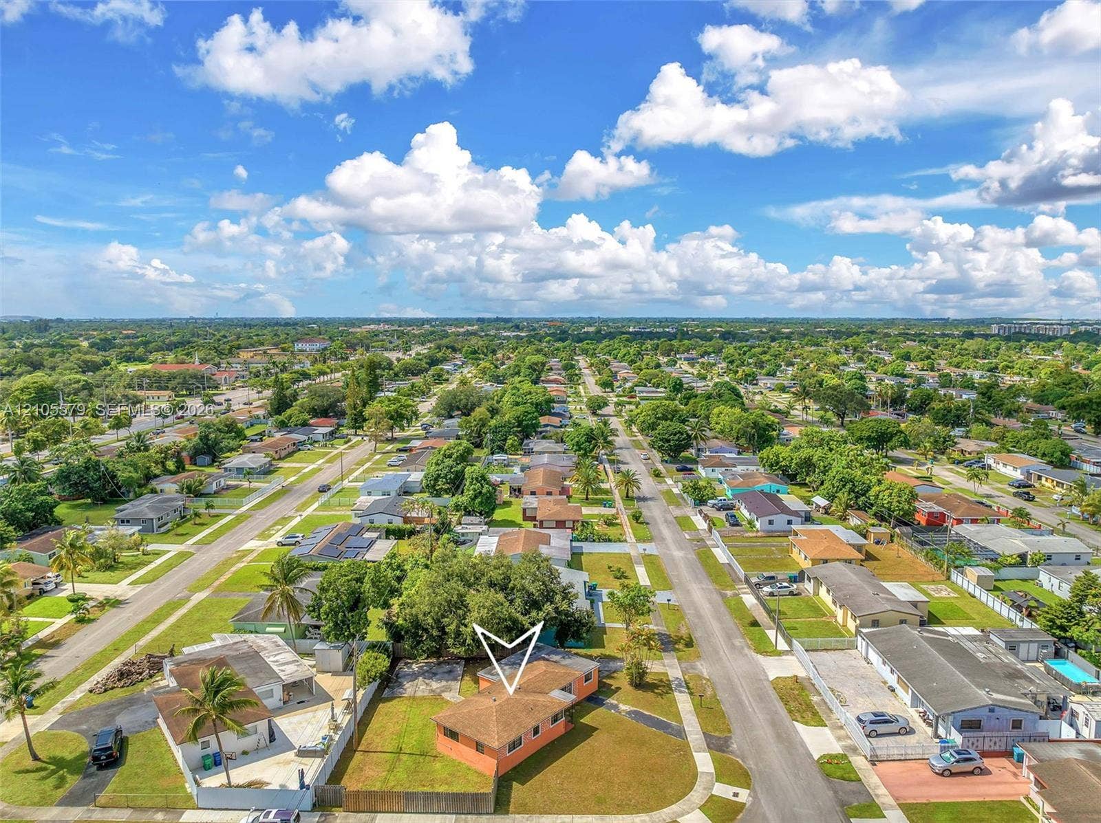 1750 NW 185th Street, Miami Gardens, FL 33056 Single-story residence featuring a hipped roof, concrete block construction, and an expansive lawn situated on a corner lot
