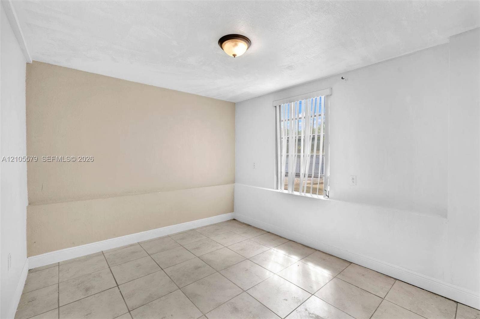 1750 NW 185th Street, Miami Gardens, FL 33056 Neutral-toned interior space featuring tile flooring, a dual-tone wall finish, and a flush-mount ceiling light