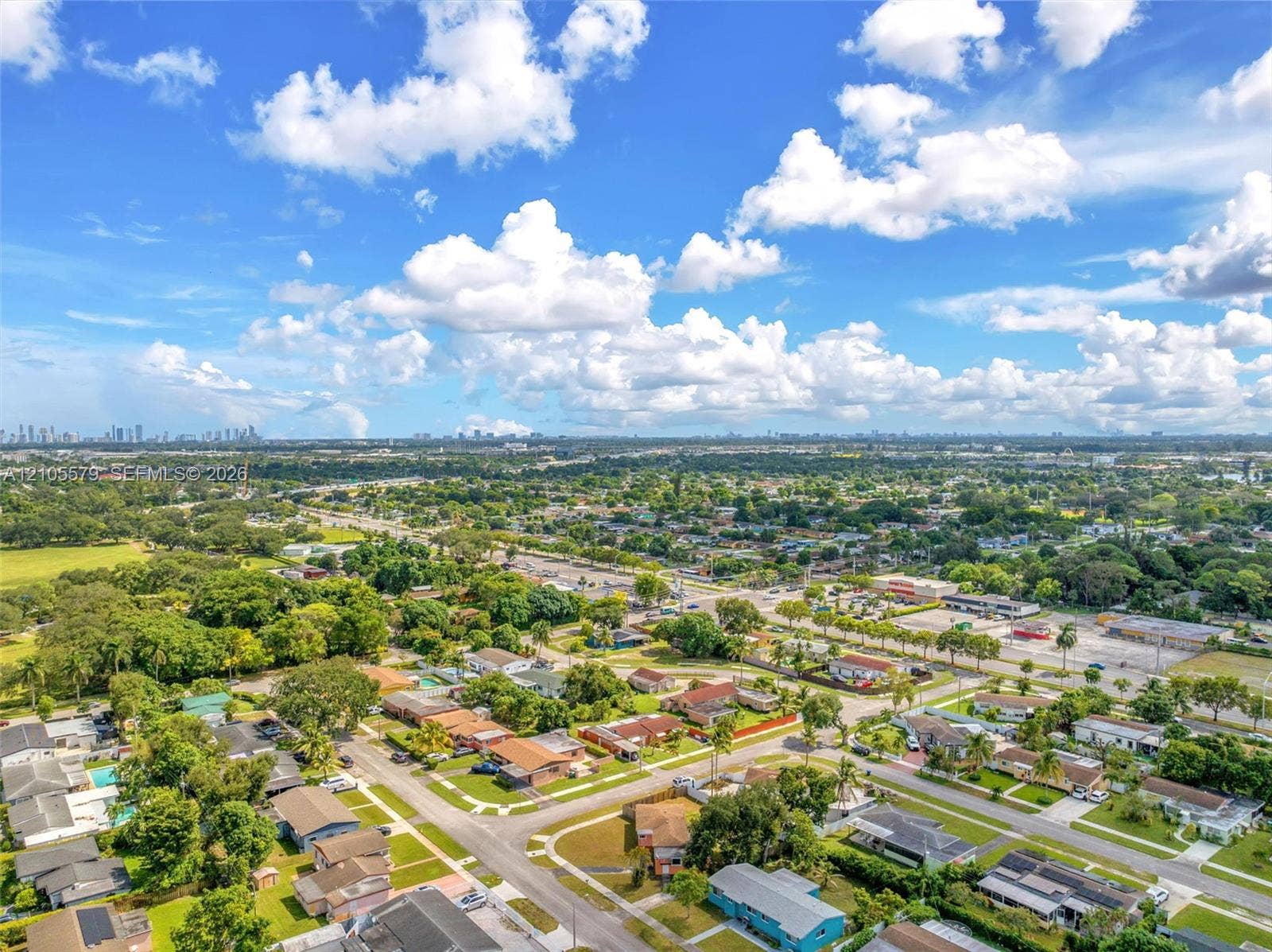 1750 NW 185th Street, Miami Gardens, FL 33056 Aerial perspective of a suburban setting featuring established landscaping, grid-patterned residential streets, mature canopy trees, and an expansive horizon line