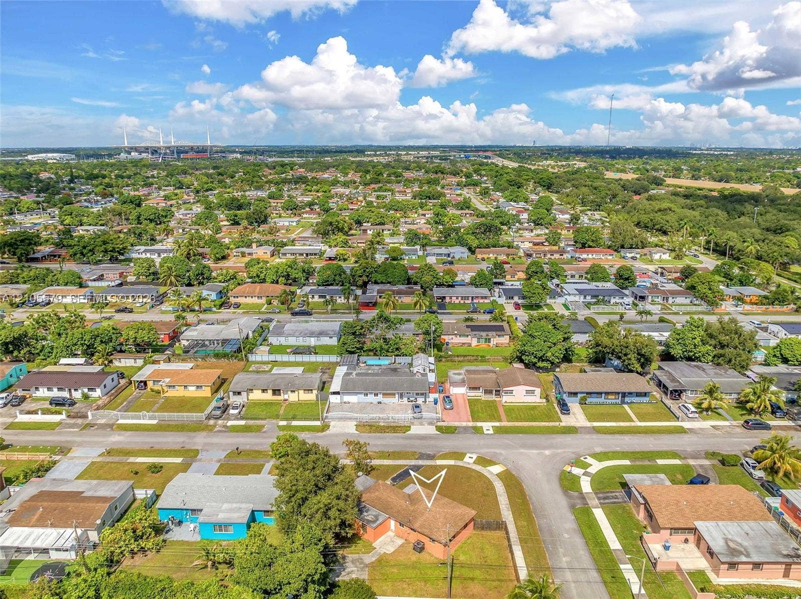 1750 NW 185th Street, Miami Gardens, FL 33056 Aerial perspective of a residential property featuring a composition shingle roof, paved driveway, and established landscaping