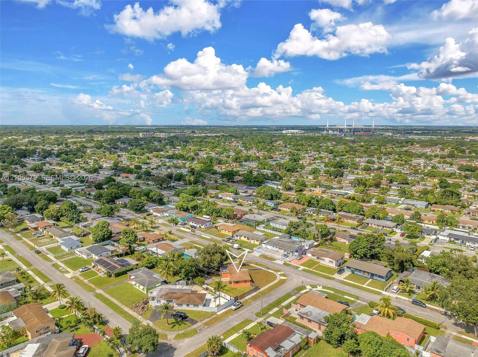 1750 NW 185th Street, Miami Gardens, FL 33056 Aerial perspective of a single-story residence situated on a corner lot featuring a fenced rear perimeter, mature landscaping, and an asphalt-shingled roof