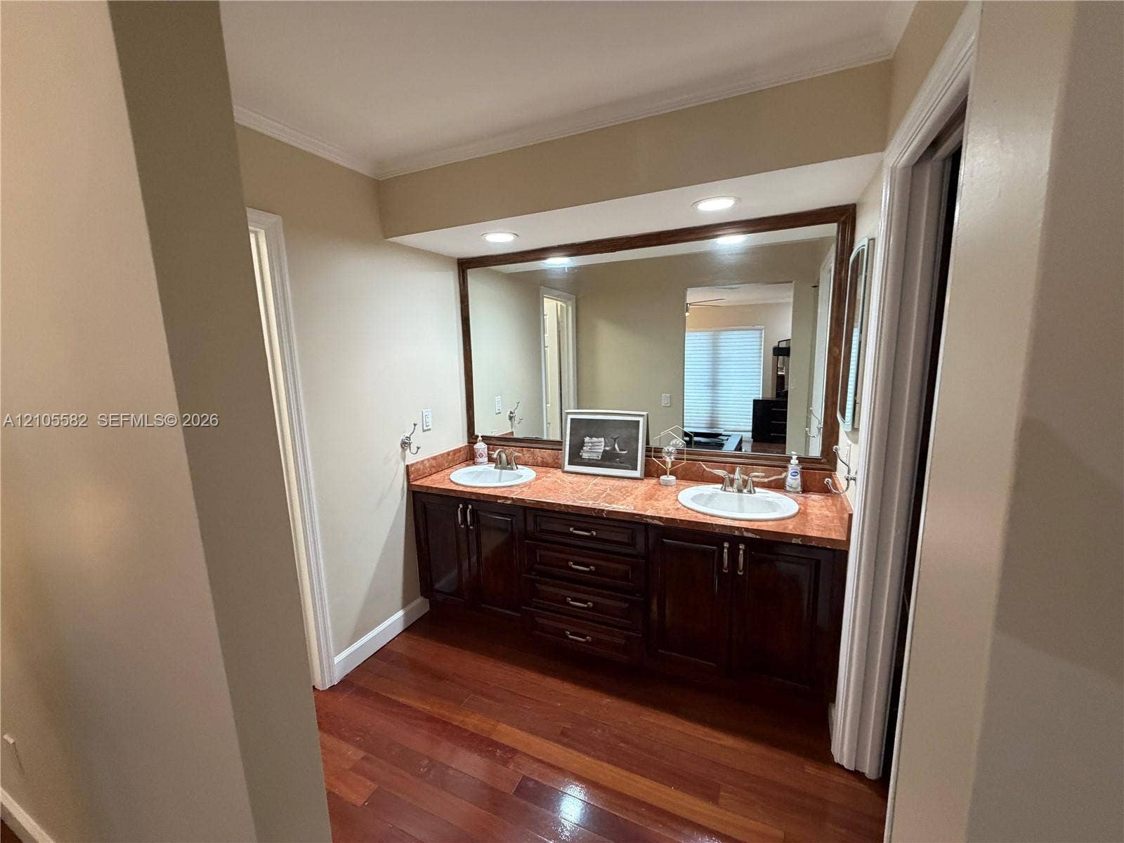 2215 NE 204th Street, Miami, Miami, FL 33180 Dual vanity with undermount sinks, stone countertop, wood-finish cabinetry, and a large wall-mounted mirror