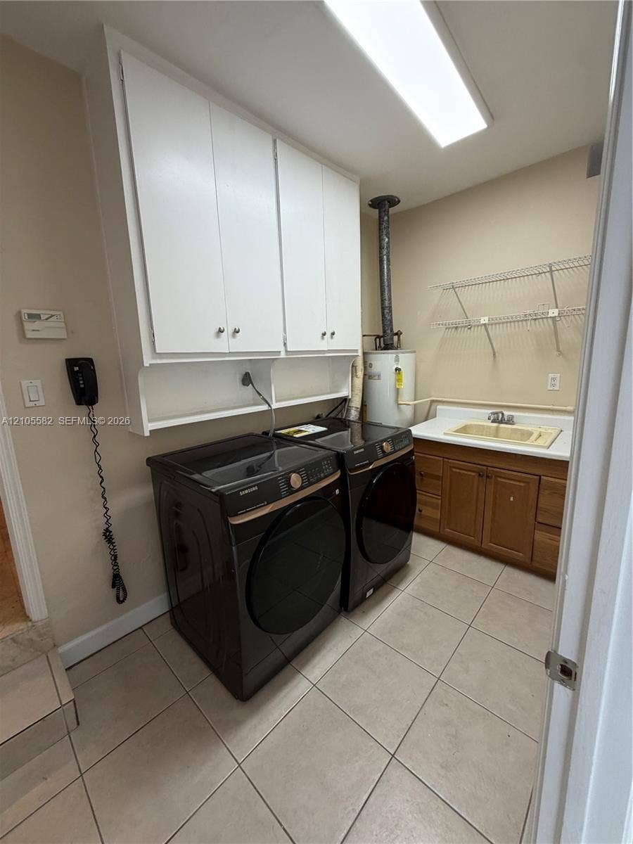 2215 NE 204th Street, Miami, Miami, FL 33180 Laundry room with tiled flooring, white upper cabinetry, a utility sink, and wall-mounted shelving
