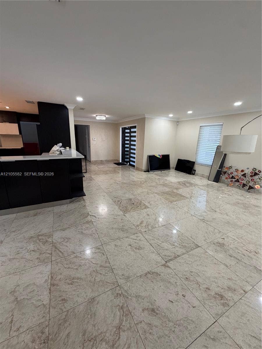 2215 NE 204th Street, Miami, Miami, FL 33180 Spacious open-concept interior featuring large format tile flooring, recessed ceiling lighting, and a contemporary entry door