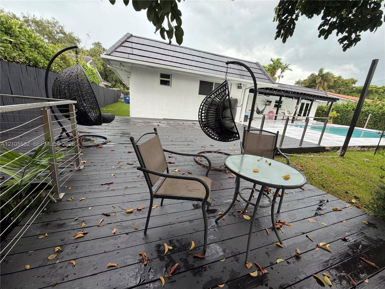 2215 NE 204th Street, Miami, Miami, FL 33180 Expansive wooden deck with cable railings and a tiled roof structure