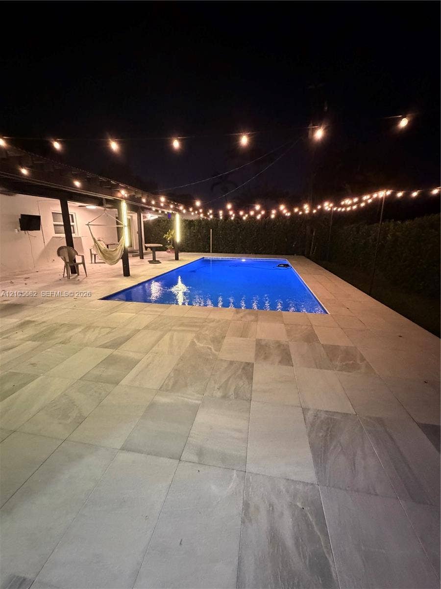 2215 NE 204th Street, Miami, Miami, FL 33180 Rectangular swimming pool with perimeter tiling, surrounded by large format tile patio