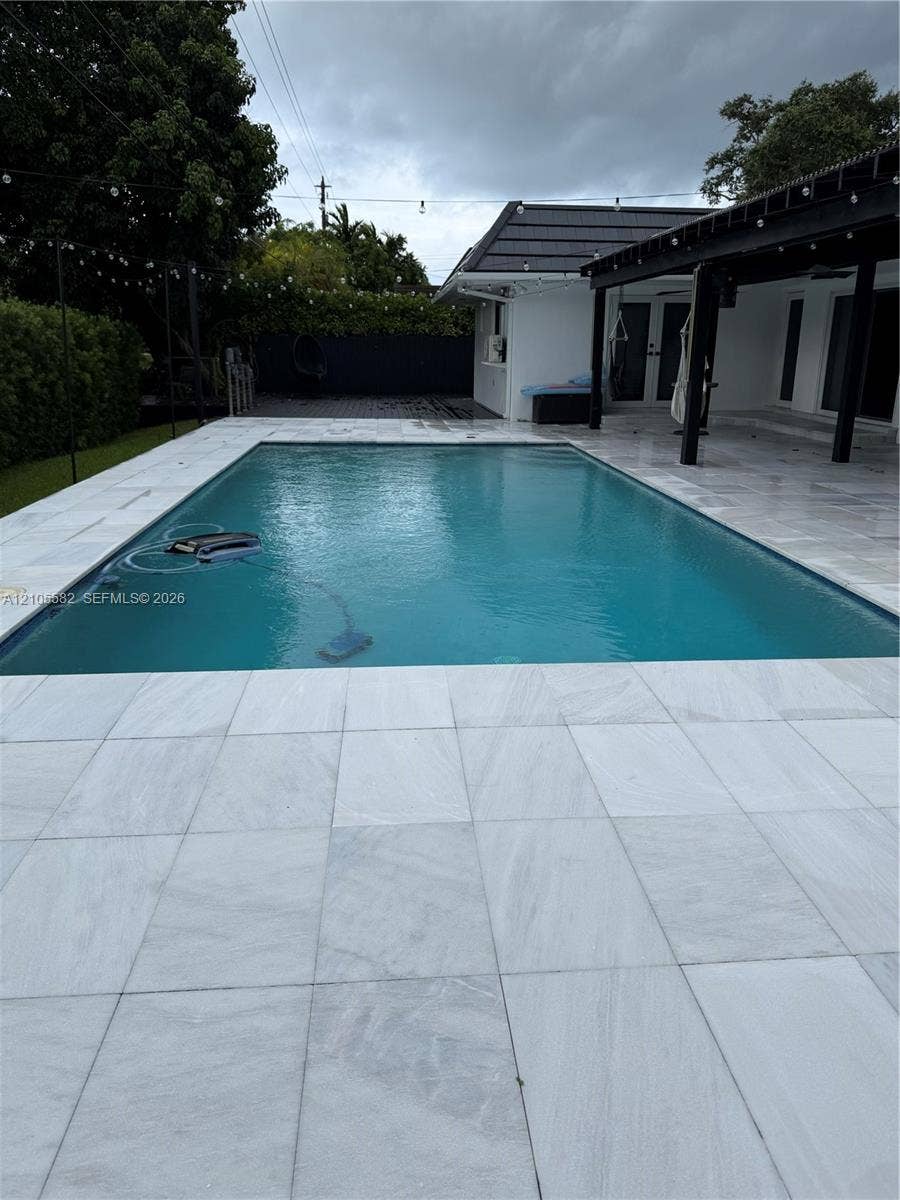 2215 NE 204th Street, Miami, Miami, FL 33180 Rectangular swimming pool with light-toned tiled coping and surrounding patio