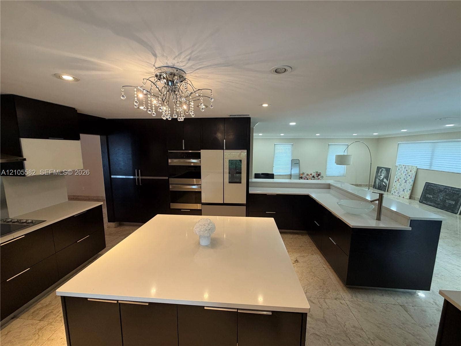2215 NE 204th Street, Miami, Miami, FL 33180 Spacious kitchen featuring dark cabinetry, expansive light-toned countertops, a multi-tiered island, and recessed lighting
