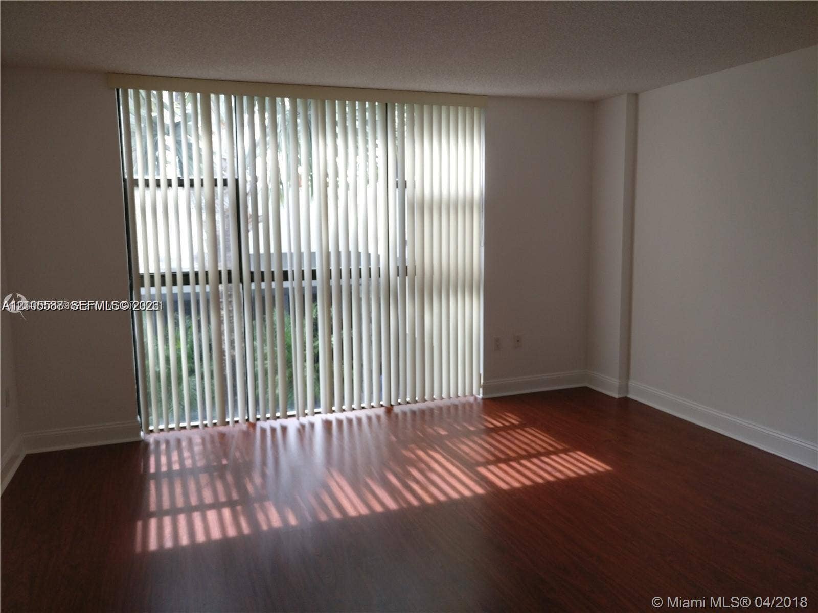 Wood-finish flooring with white baseboards and light-colored walls