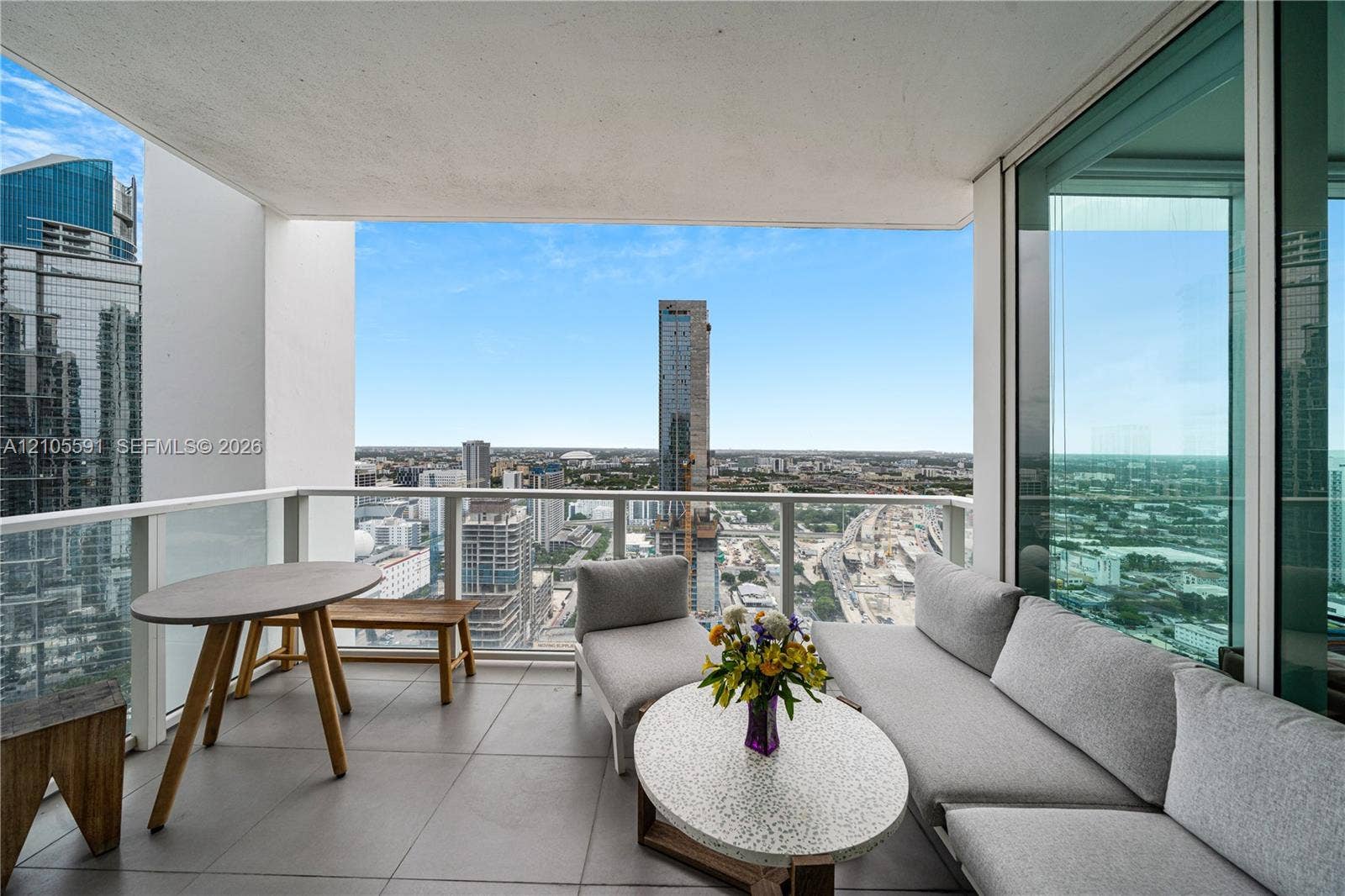 Balcony with tile flooring, glass railings, and expansive city scenery