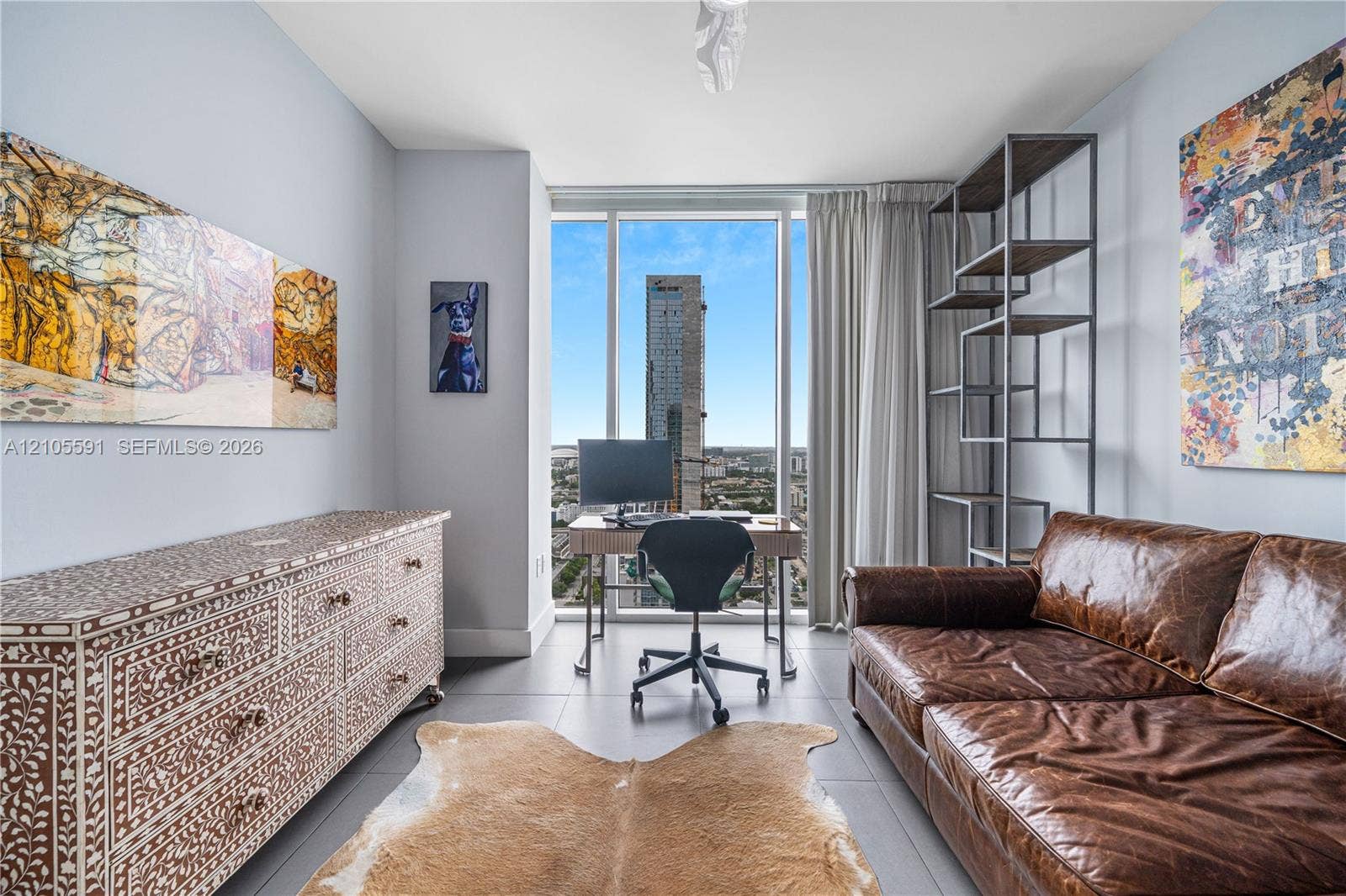 Floor-to-ceiling windows, light gray wall color, built-in shelving, and light wood-finish flooring