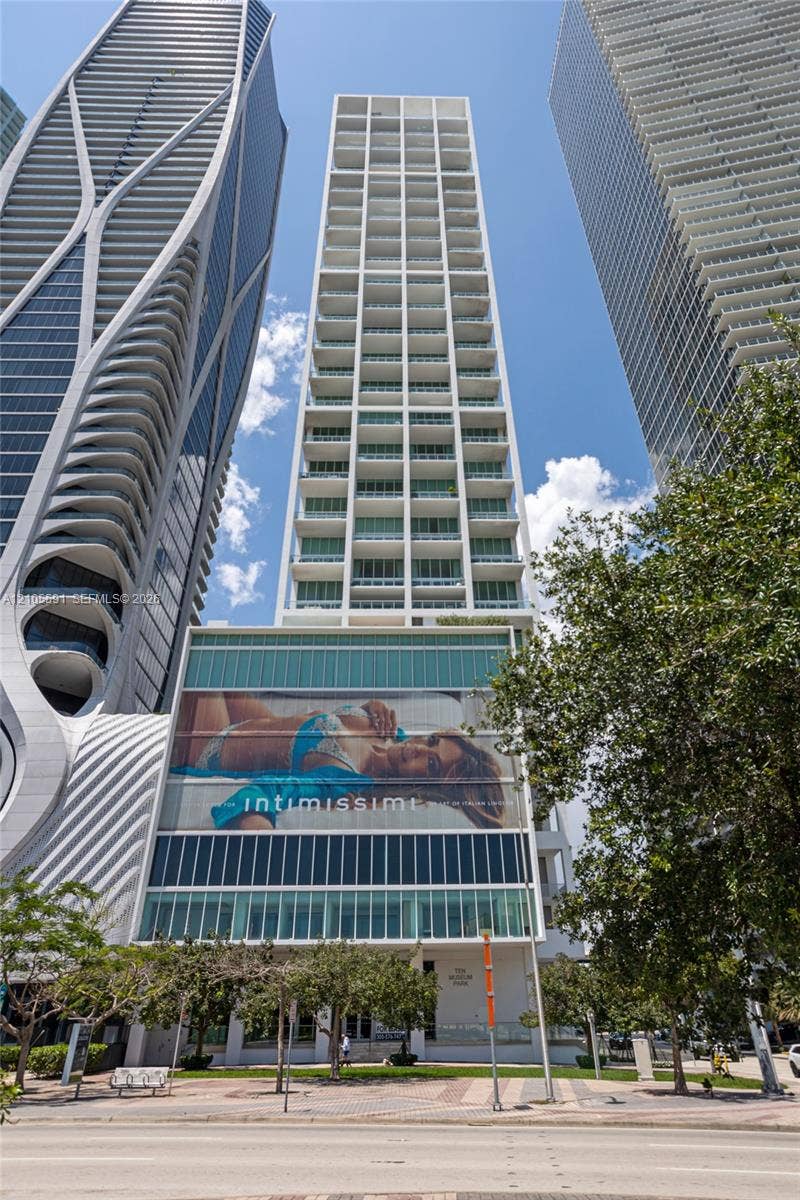 Modern high-rise residential building featuring a grid-patterned facade and individual balconies