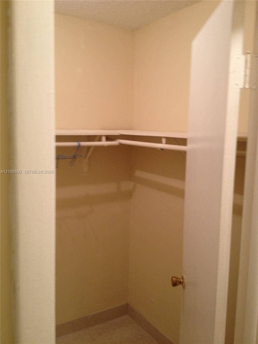 Walk-in closet featuring multi-level shelving, hanging rods, and light-toned wall paint