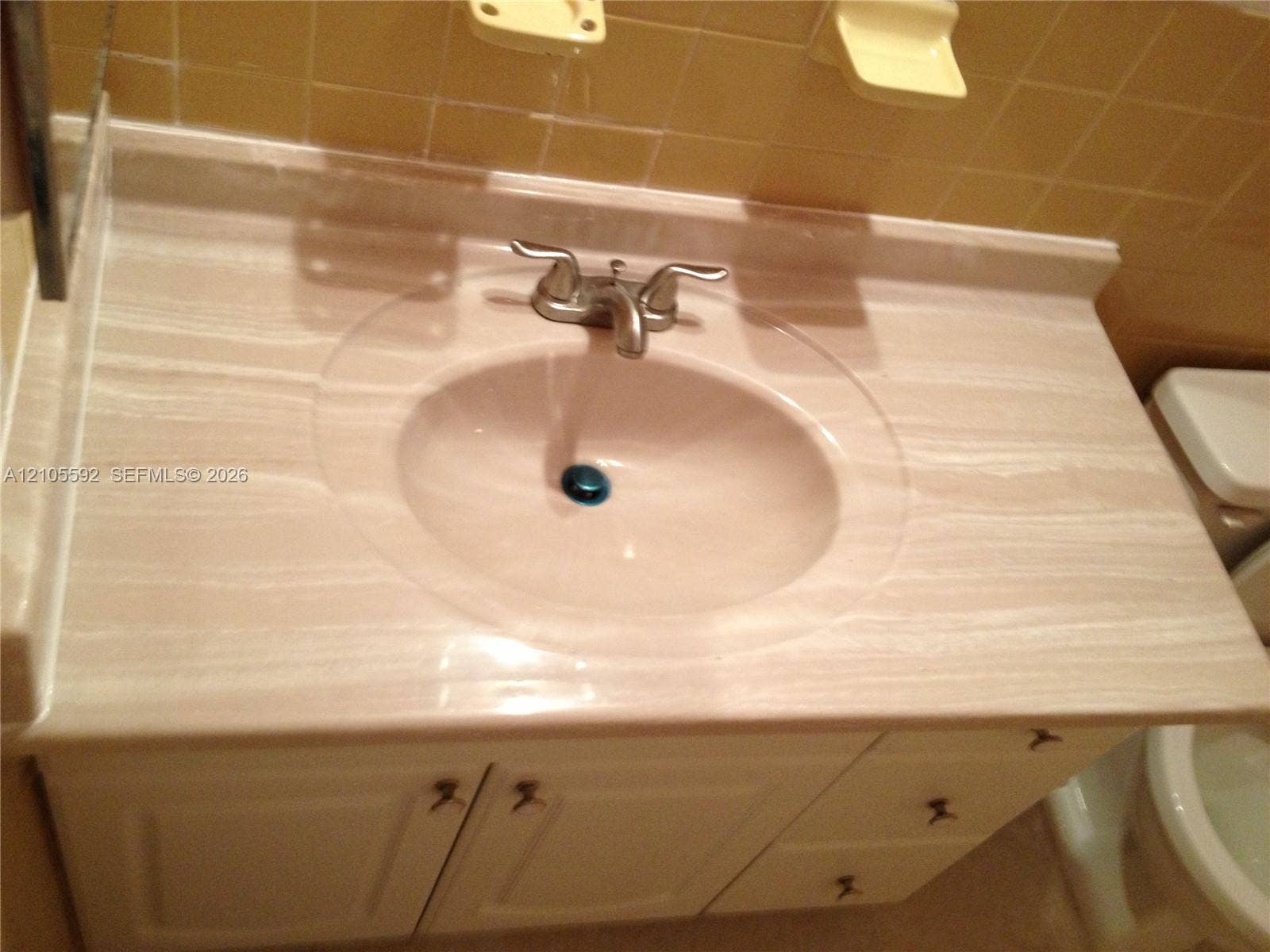 Built-in vanity with a single basin sink, dual-handle faucet, and white cabinet doors