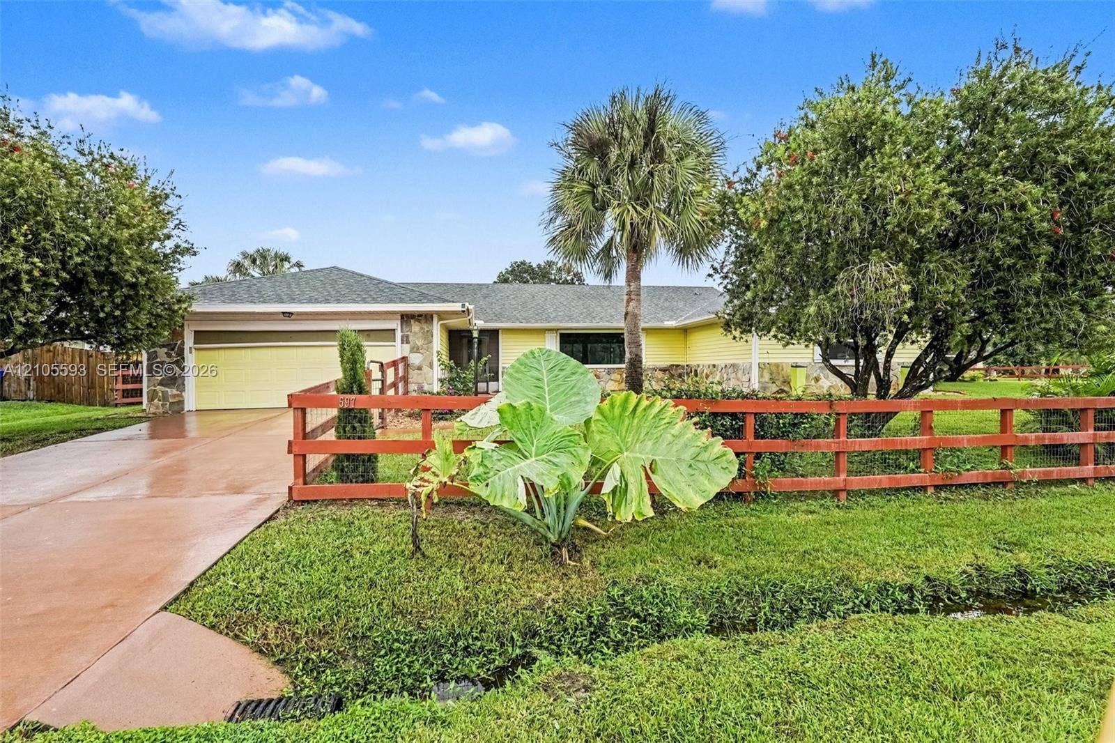 597 Grace Street, Sebastian, FL 32958 Single-story residence featuring stone masonry and horizontal siding, an attached garage, and a wood-style perimeter fence