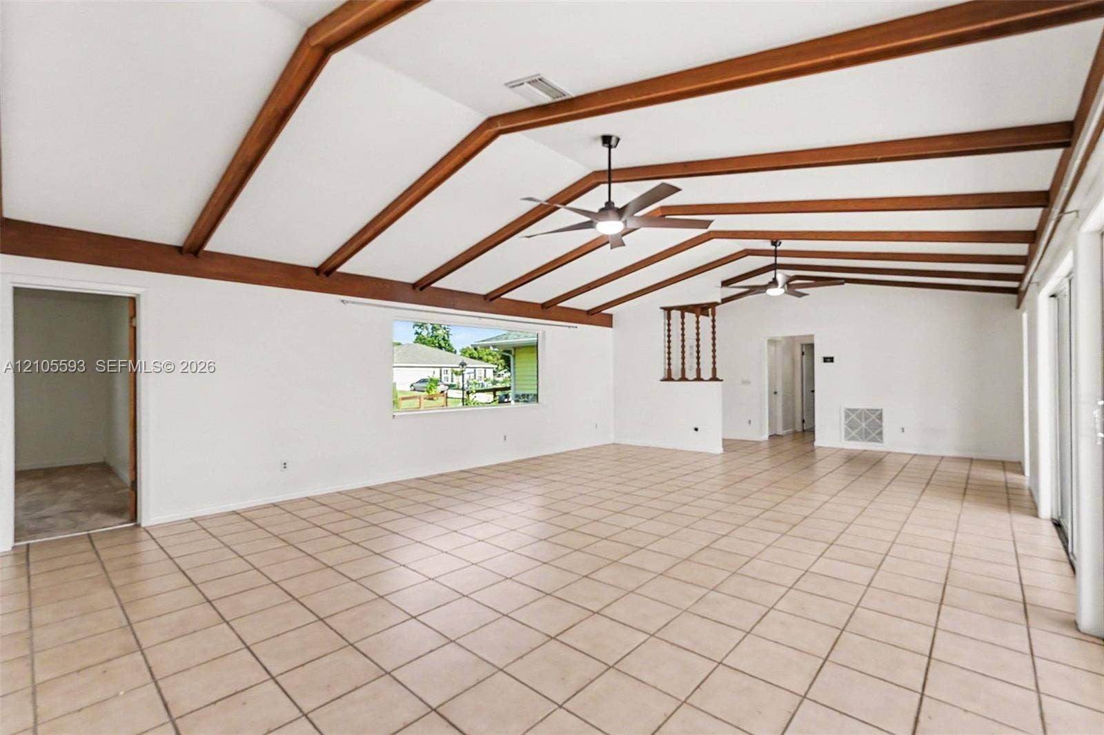 597 Grace Street, Sebastian, FL 32958 Vaulted ceiling featuring exposed wood beams, ceramic tile flooring, and dual ceiling fans