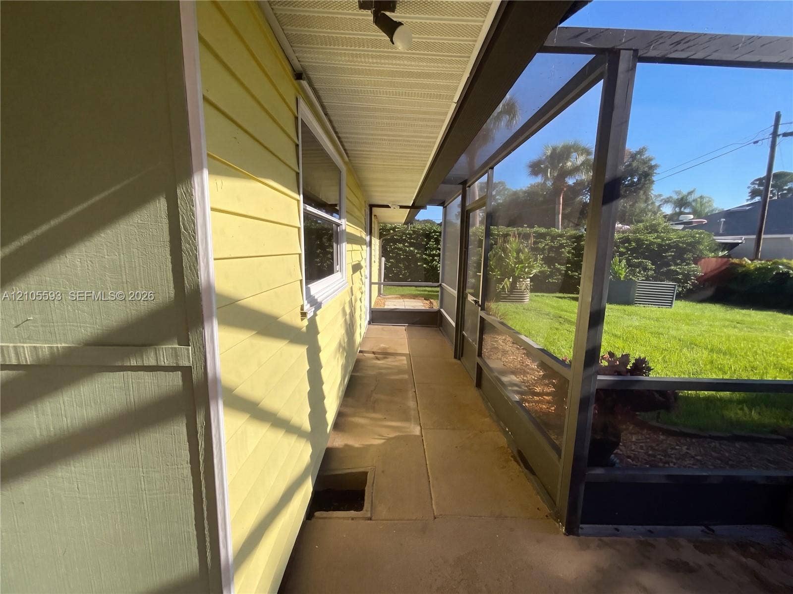 597 Grace Street, Sebastian, FL 32958 Screened-in porch featuring horizontal lap siding, a concrete floor, and direct access to an open grass yard