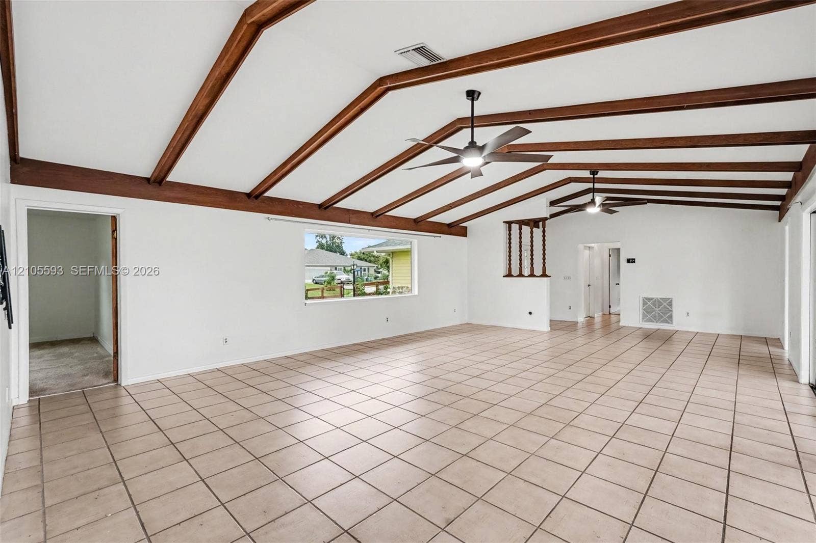 597 Grace Street, Sebastian, FL 32958 Vaulted ceilings featuring exposed wood beams, ceramic tile flooring, and dual ceiling fans