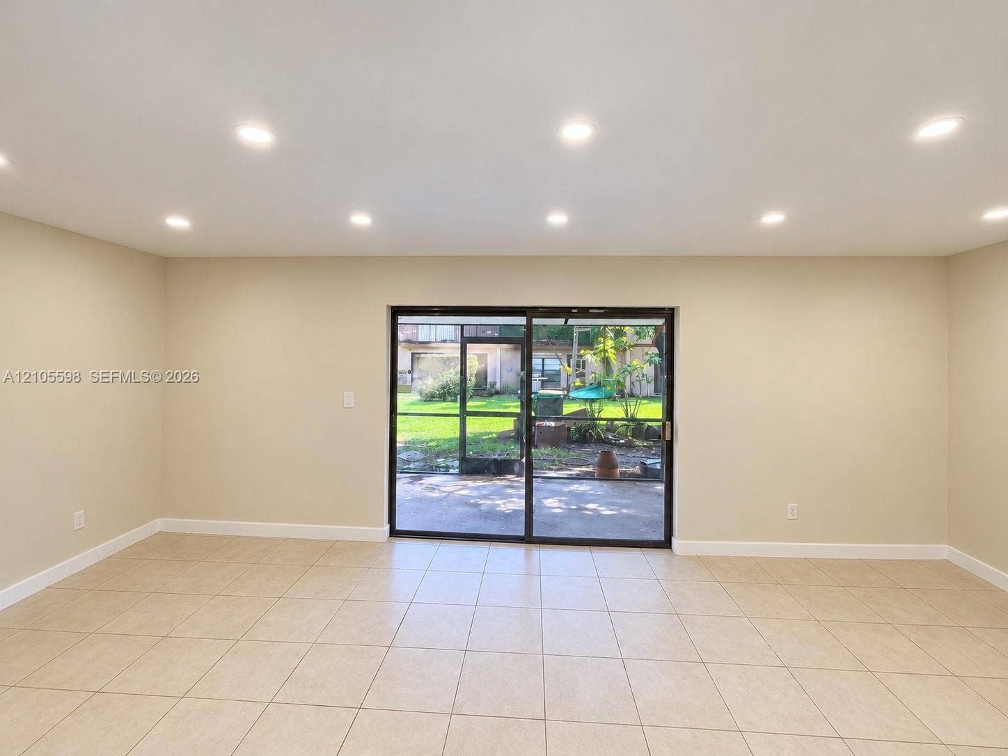 Recessed lighting, tile flooring, sliding glass door, and neutral paint tones
