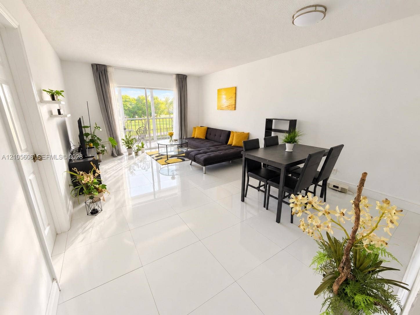 Open-concept living space featuring high-gloss tile flooring, flush-mount ceiling lighting, and sliding glass doors with access to an exterior balcony