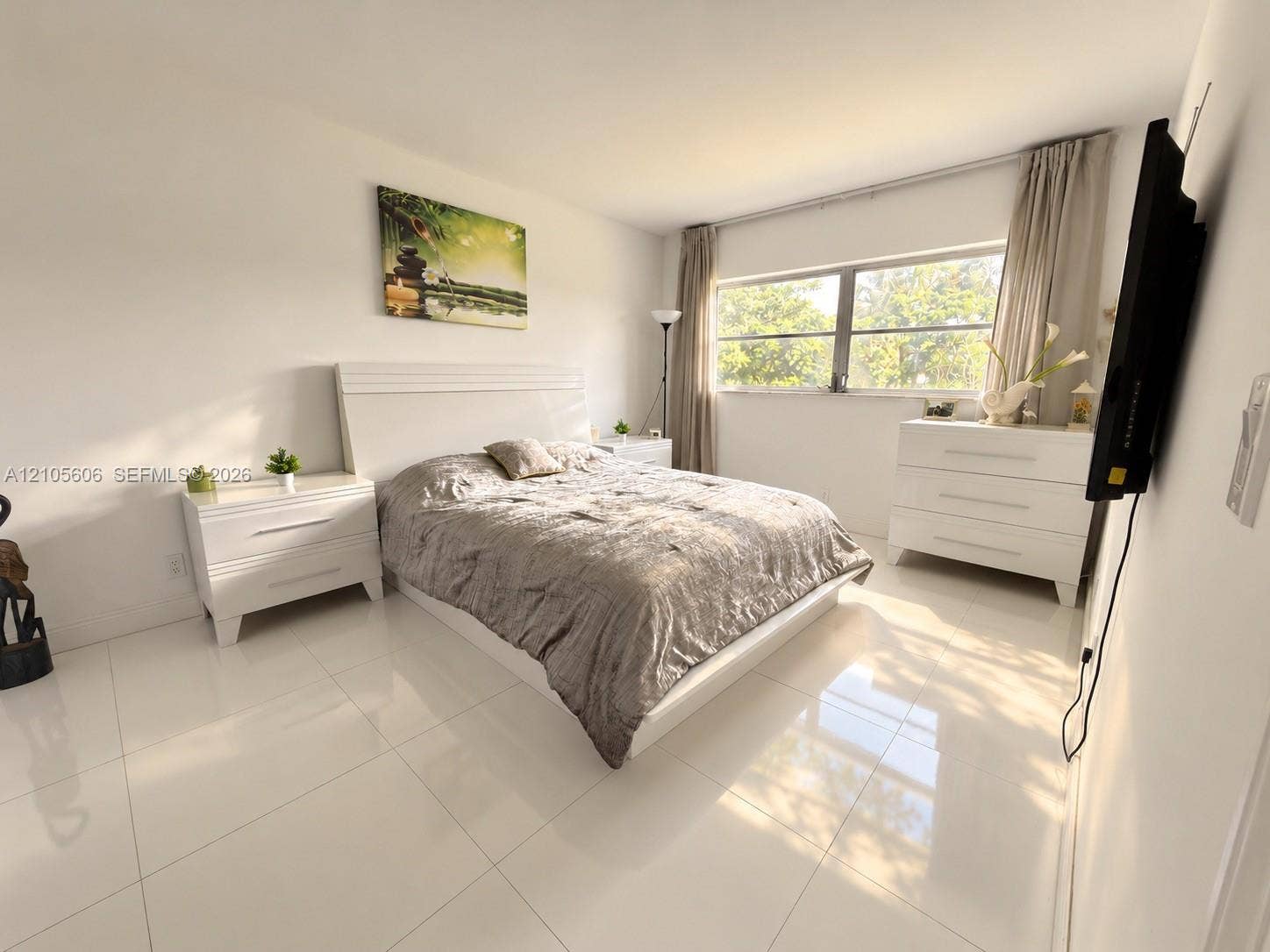 Large-format porcelain tile flooring and a wide, multi-pane window allowing natural light