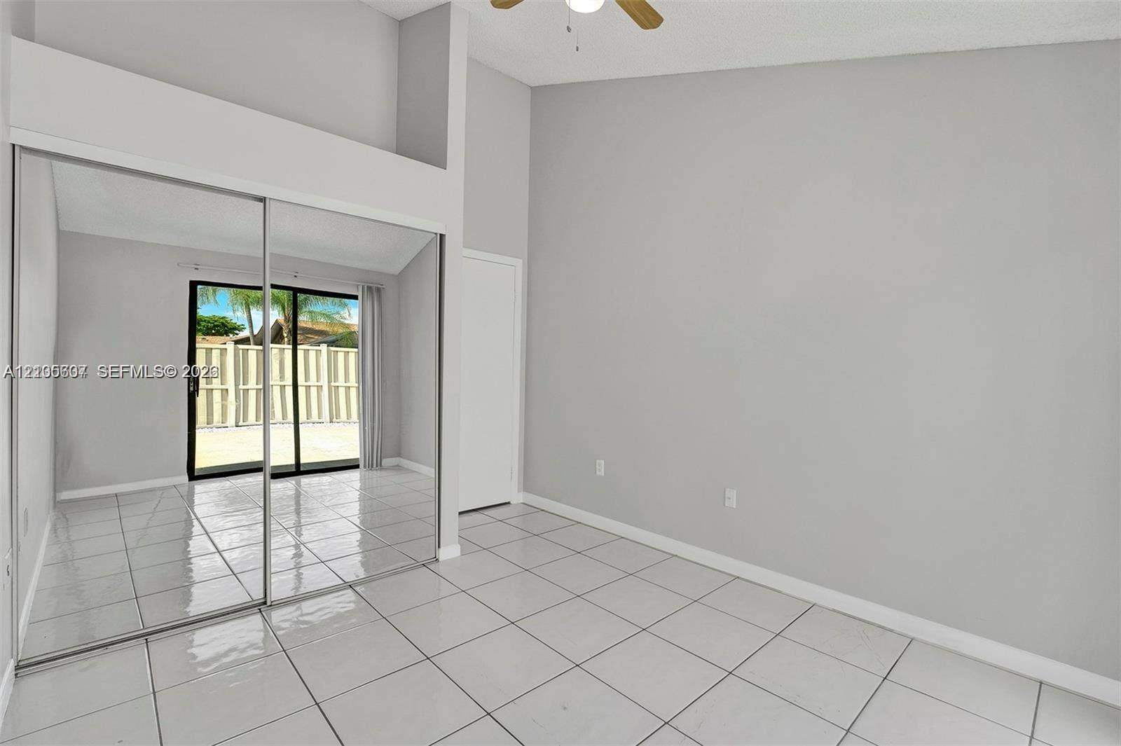 9892 Boca Gardens Parkway, #A, Boca Raton, FL 33496 Mirrored closet doors, tiled flooring, sliding glass patio doors, and a ceiling fan