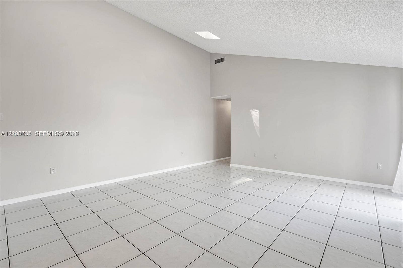 9892 Boca Gardens Parkway, #A, Boca Raton, FL 33496 Vaulted ceiling, white square tile flooring, light neutral wall paint, recessed lighting, and an arched doorway