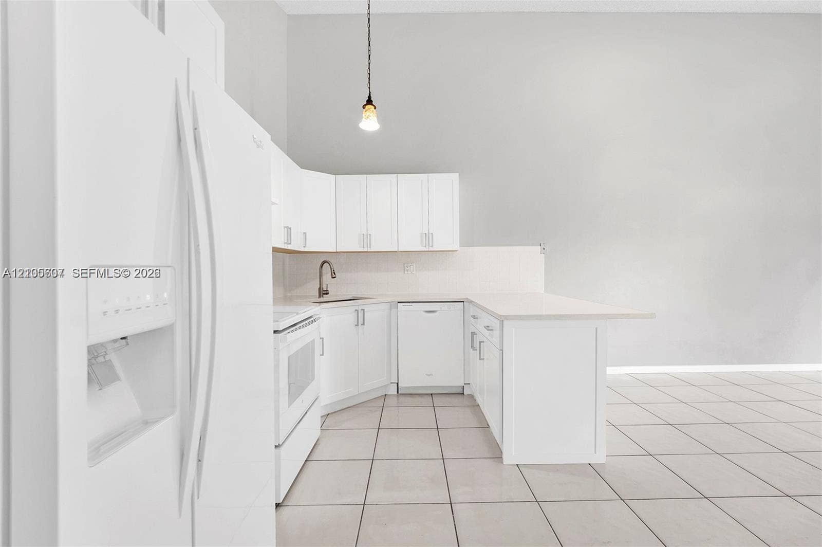 9892 Boca Gardens Parkway, #A, Boca Raton, FL 33496 Kitchen featuring white cabinetry, white appliances, a peninsula with an integrated breakfast bar, and tile flooring