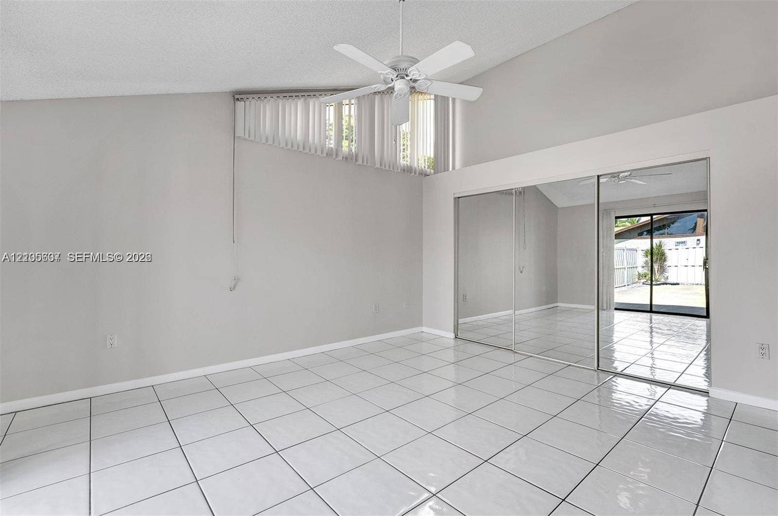 9892 Boca Gardens Parkway, #A, Boca Raton, FL 33496 Vaulted ceiling with a ceiling fan, white tile flooring, and mirrored closet doors