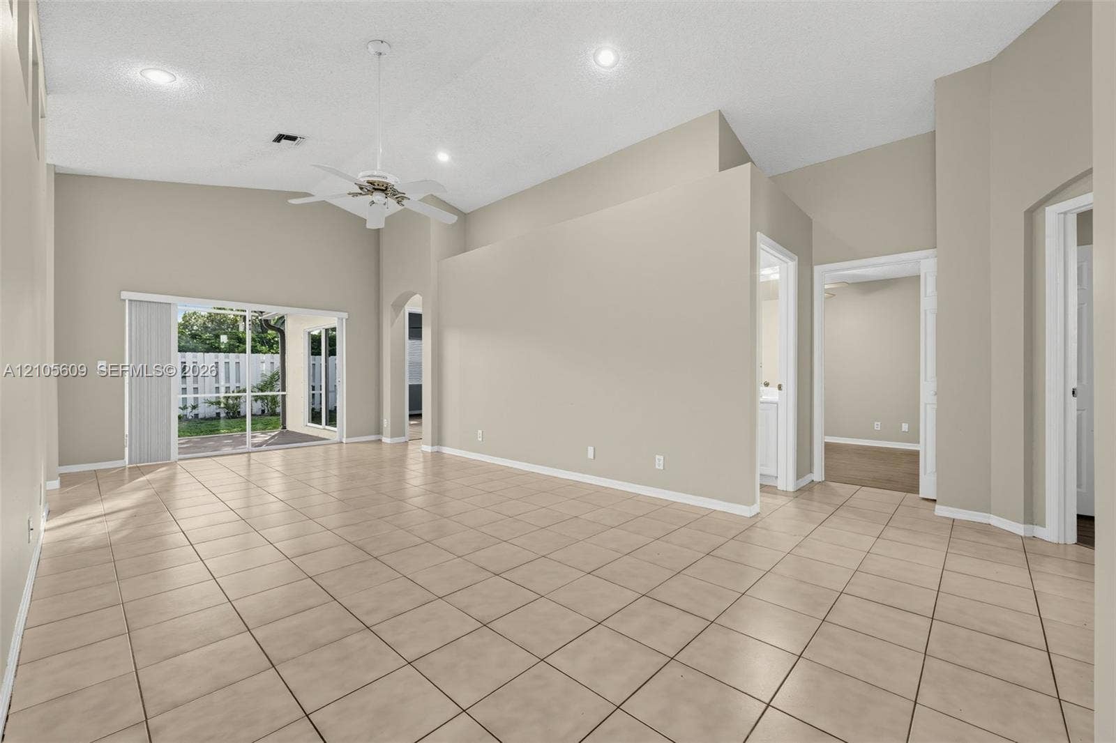 Interior space featuring vaulted ceilings, tile flooring, recessed lighting, a ceiling fan, and sliding glass doors