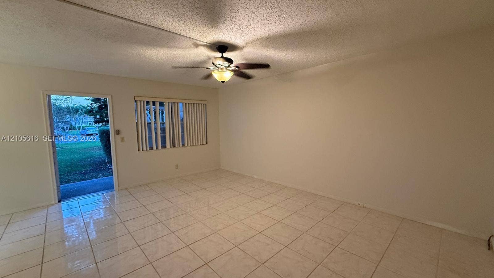 573 Durham U, #573, Deerfield Beach, FL 33442 Neutral interior space featuring polished tile flooring, a multi-blade ceiling fan with integrated lighting, and vertical window blinds