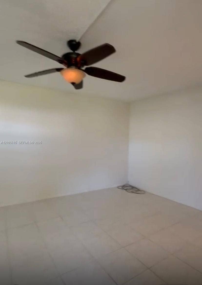 573 Durham U, #573, Deerfield Beach, FL 33442 Interior space featuring neutral wall paint, tile flooring, and a ceiling fan with integrated lighting