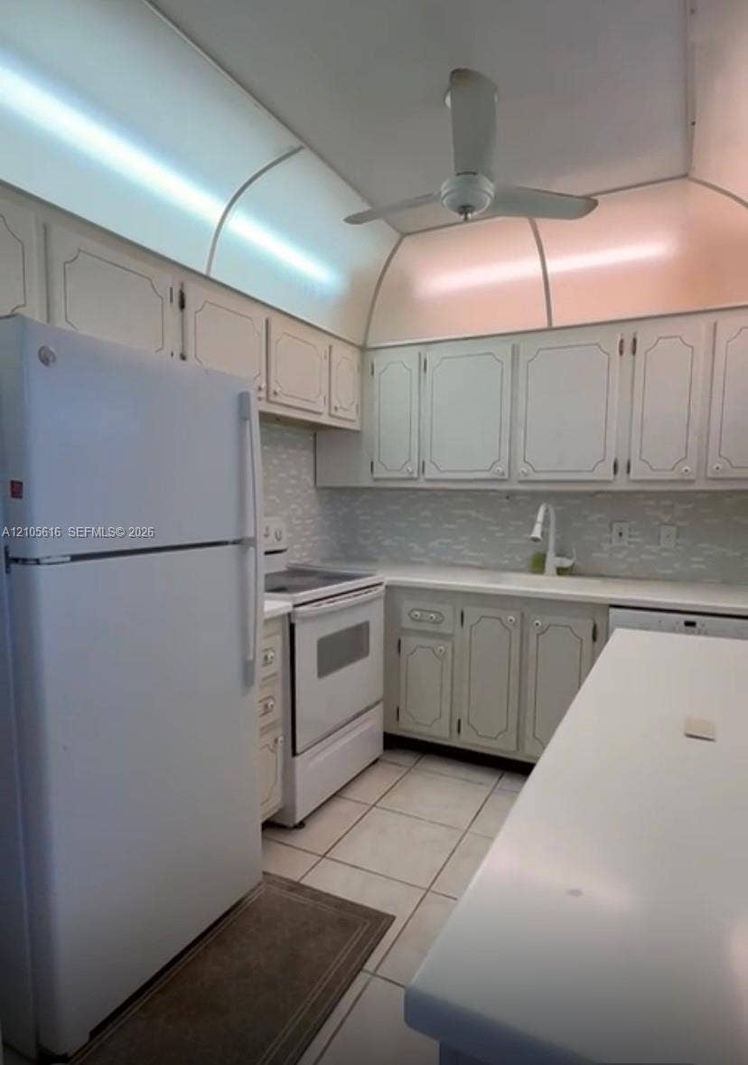 573 Durham U, #573, Deerfield Beach, FL 33442 Kitchen featuring white cabinetry with decorative trim, stone-composite countertops, patterned tile backsplash, ceramic tile flooring, and integrated ceiling lighting