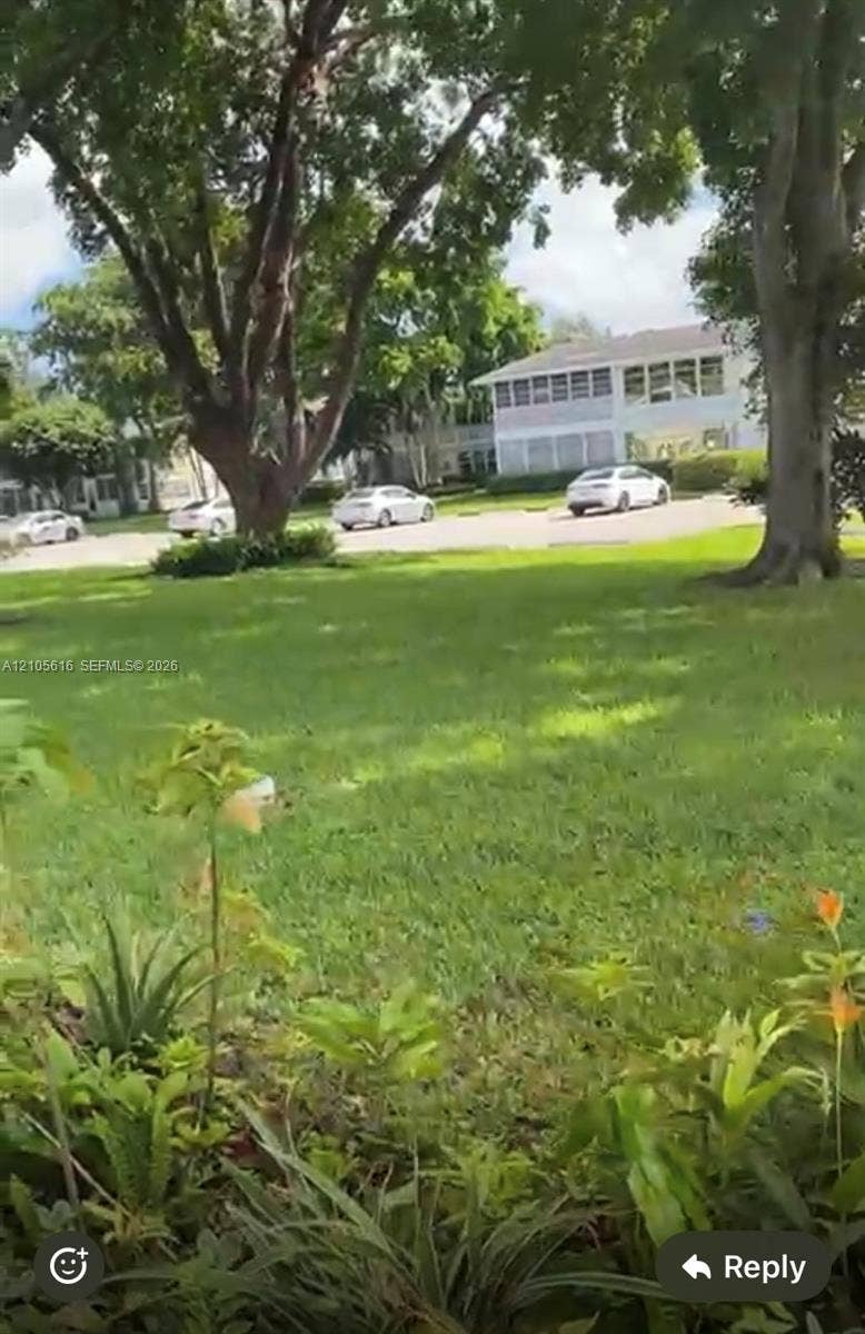 573 Durham U, #573, Deerfield Beach, FL 33442 Ground-level exterior featuring a manicured lawn, mature trees, and established shrubbery