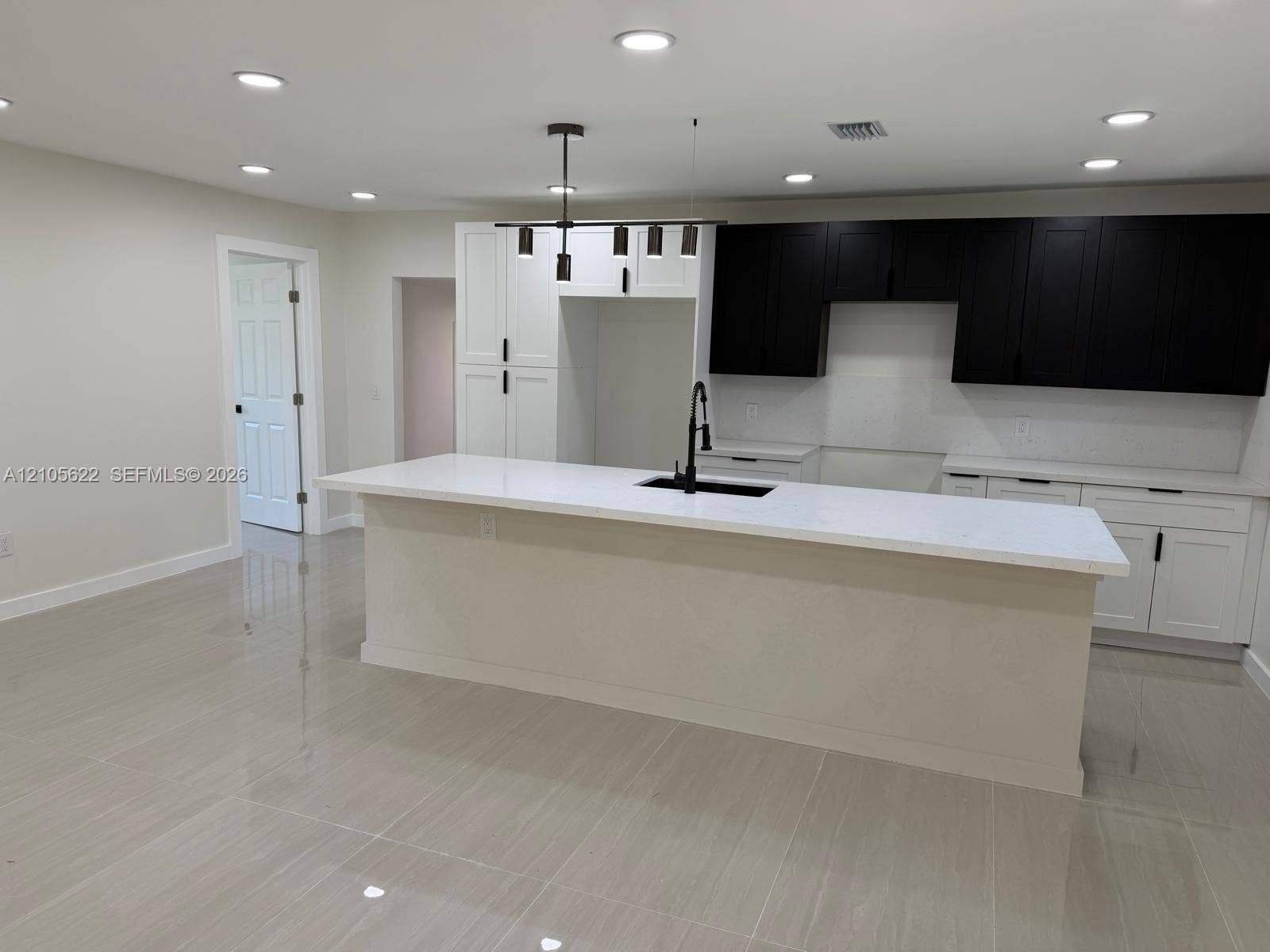 9728 Little River Drive, Miami, FL 33147 Kitchen featuring a central island with a solid surface countertop, high-contrast two-tone cabinetry, recessed ceiling lighting, and tile flooring