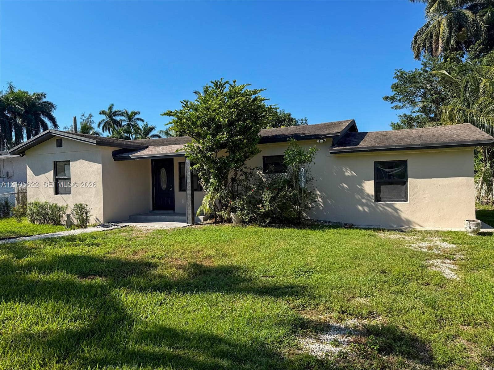 9728 Little River Drive, Miami, FL 33147 Single-story exterior featuring a stucco facade, covered front entryway, and dark-frame windows