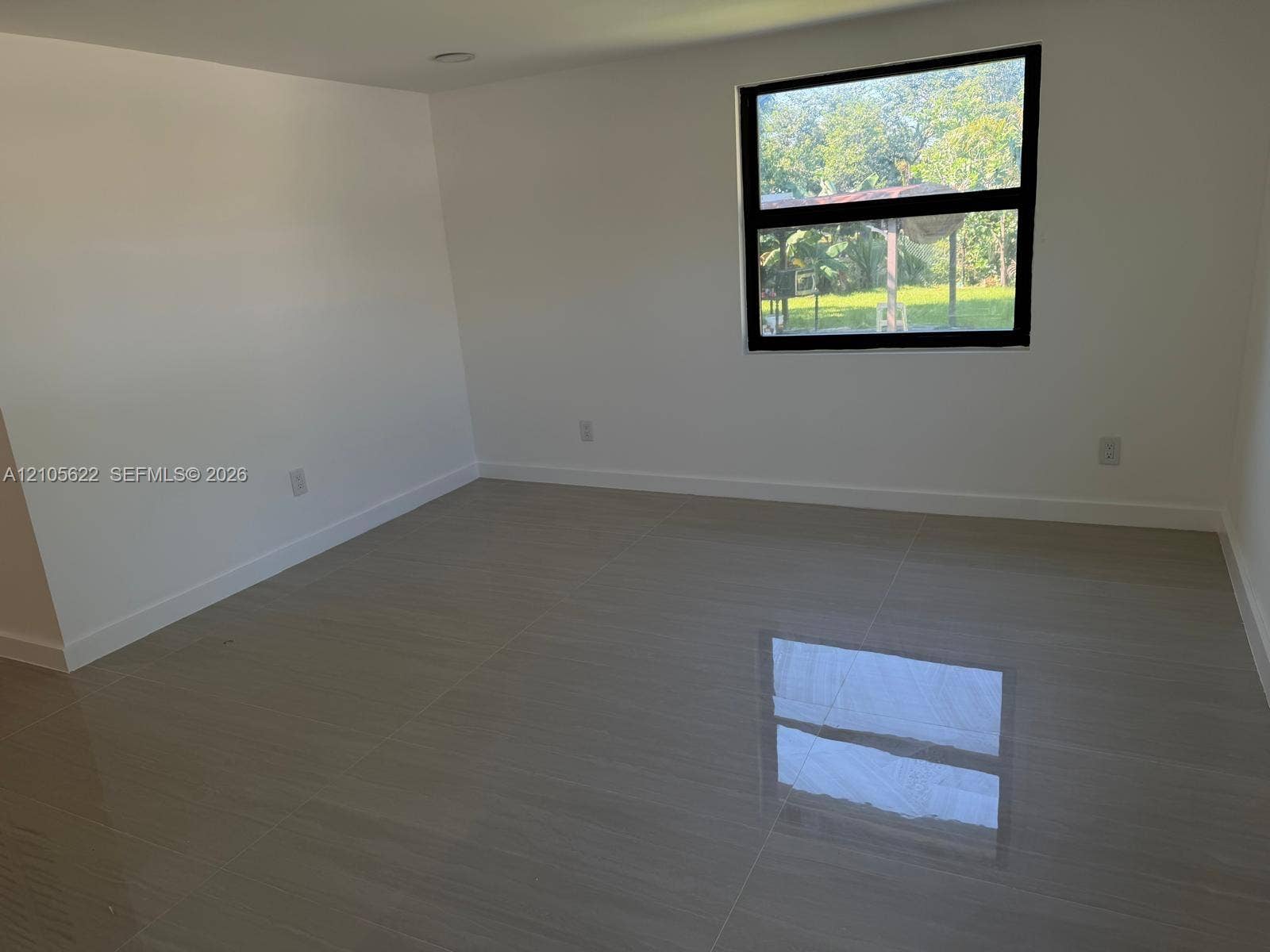 9728 Little River Drive, Miami, FL 33147 Large format tile flooring, neutral wall finishes, and a dark-framed picture window
