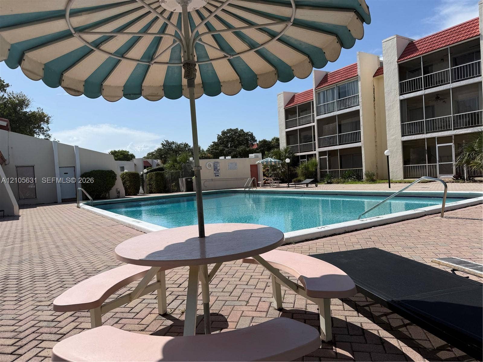 610 NW 13th Street, #0140, Boca Raton, FL 33486 Community pool featuring a concrete deck with brick-paver surfacing and multi-story structures with balconies