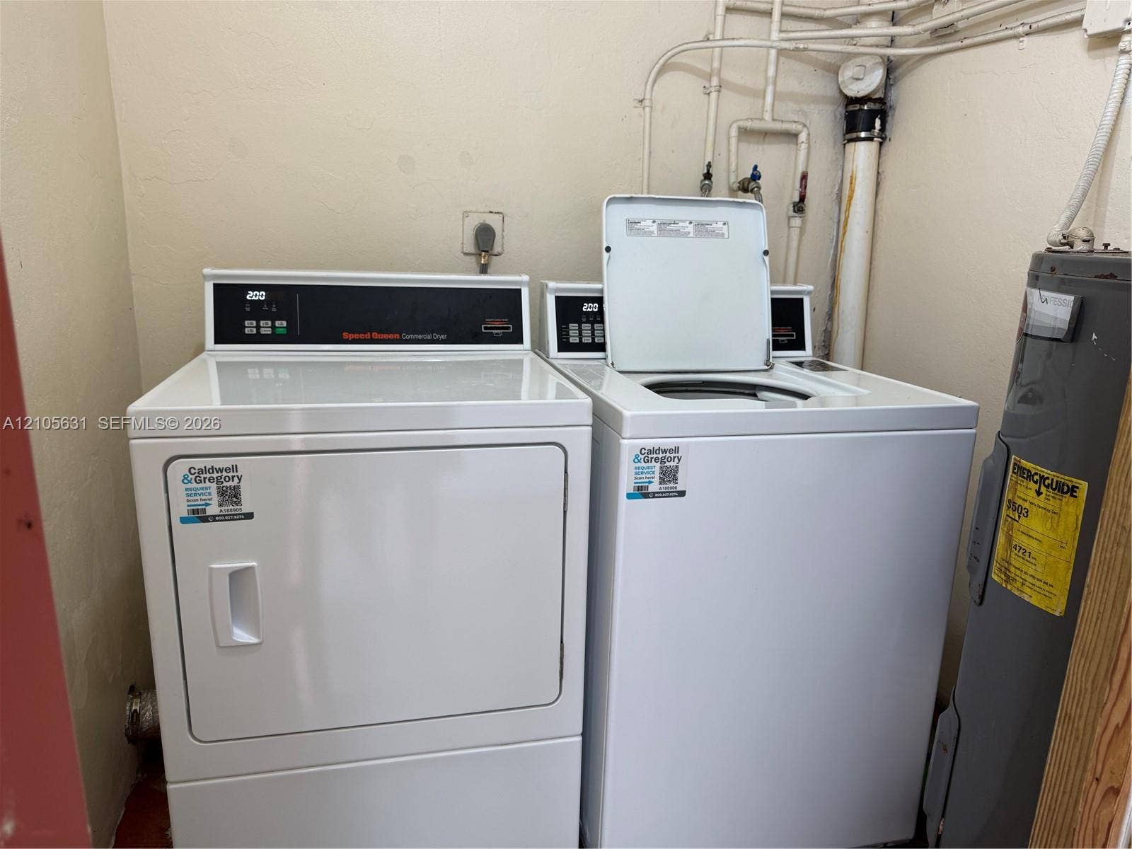 610 NW 13th Street, #0140, Boca Raton, FL 33486 Dedicated laundry area featuring a white top-load washer, a front-load dryer, and an integrated water heater
