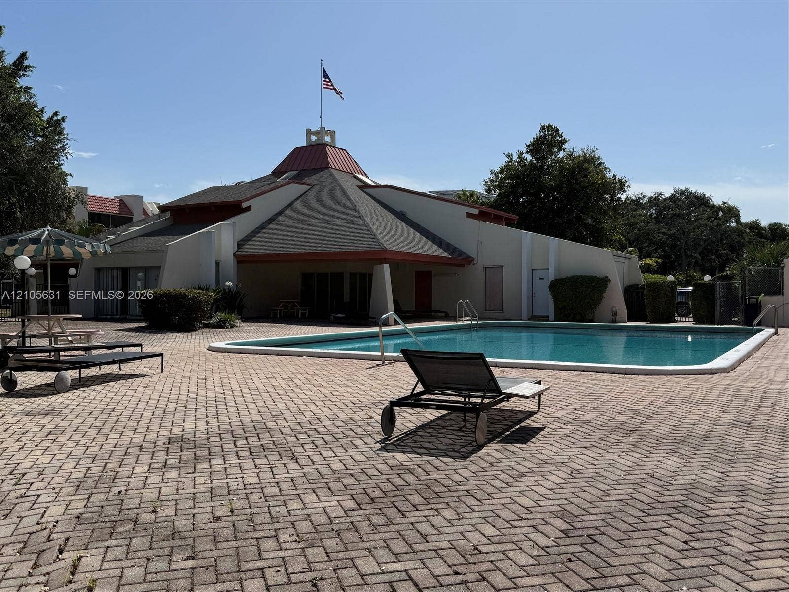 610 NW 13th Street, #0140, Boca Raton, FL 33486 In-ground swimming pool with surrounding paver deck, featuring a multi-faceted roof structure and a central decorative cupola