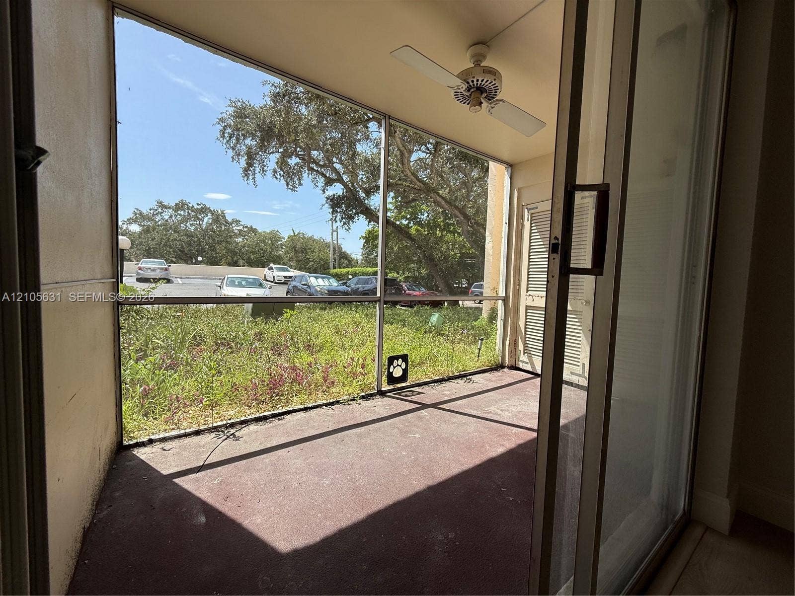 610 NW 13th Street, #0140, Boca Raton, FL 33486 Screened-in patio featuring a ceiling fan, sliding glass door, and solid flooring