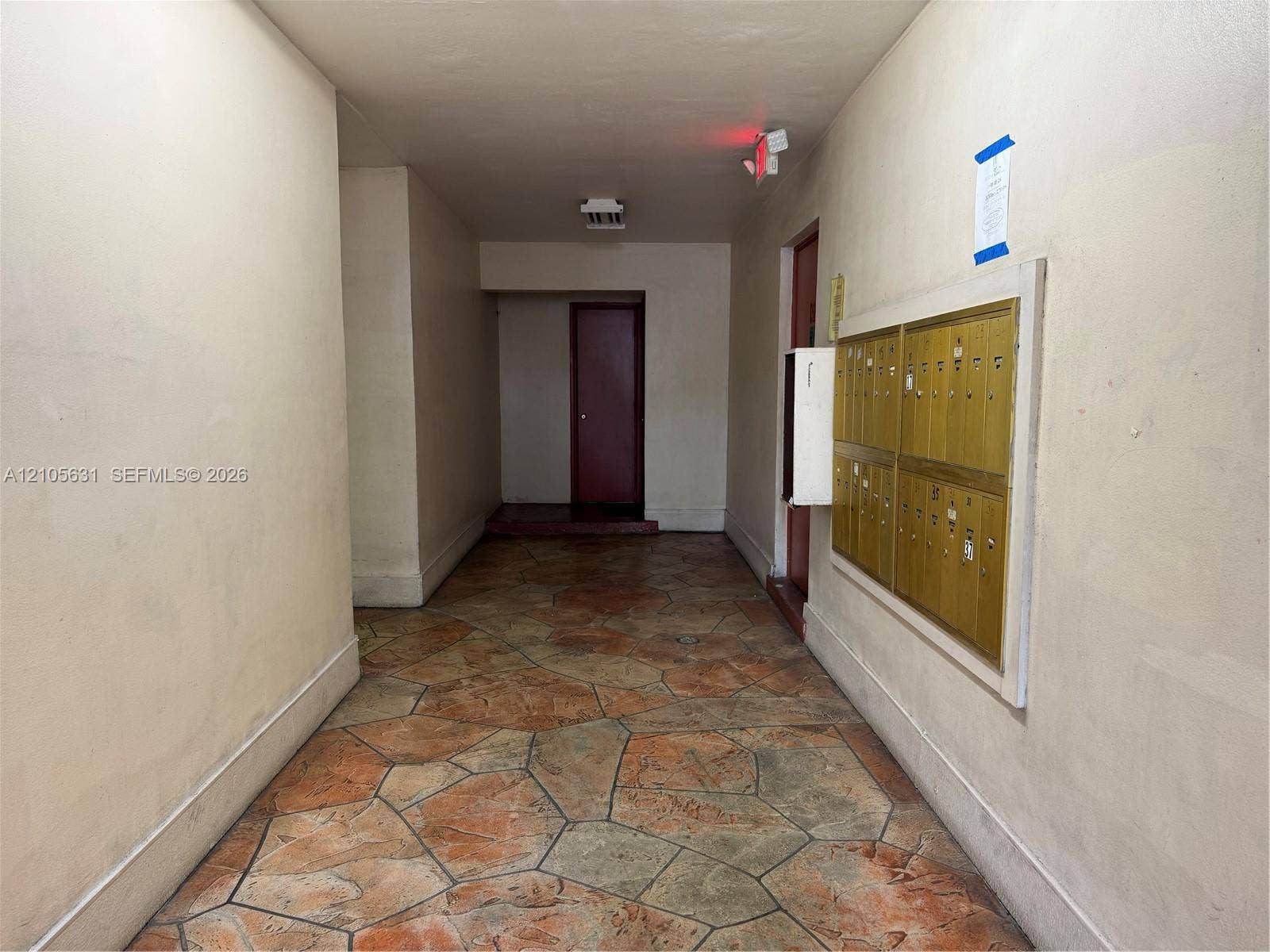 610 NW 13th Street, #0140, Boca Raton, FL 33486 Interior hallway featuring flagstone-style flooring and a wall-mounted brass mail station