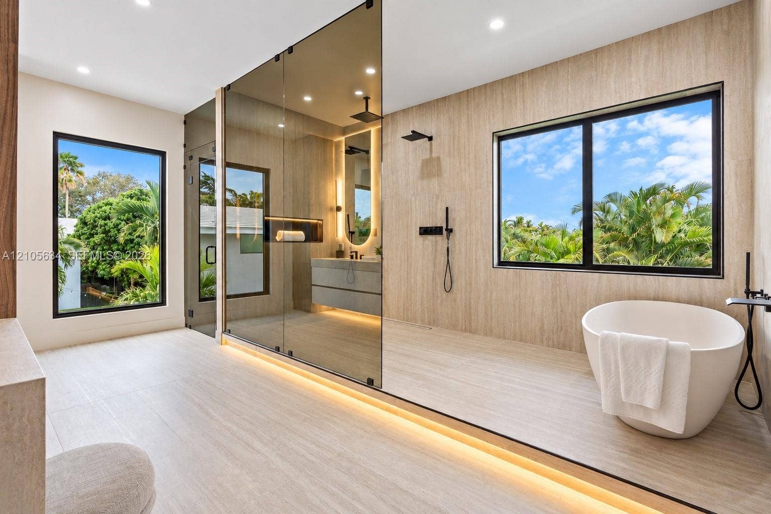 623 NE 16th Terrace, Fort Lauderdale, FL 33304 Bathroom featuring a freestanding oval soaking tub, expansive glass-enclosed shower, wood-finish wall and floor tiling, matte black fixtures, and recessed LED accent lighting