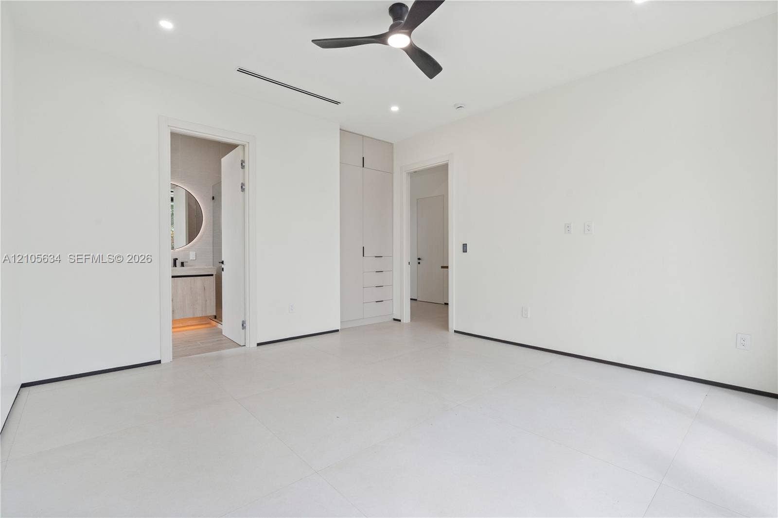 623 NE 16th Terrace, Fort Lauderdale, FL 33304 Neutral interior featuring large-format tile flooring, built-in floor-to-ceiling cabinetry, recessed lighting, and a modern three-blade ceiling fan