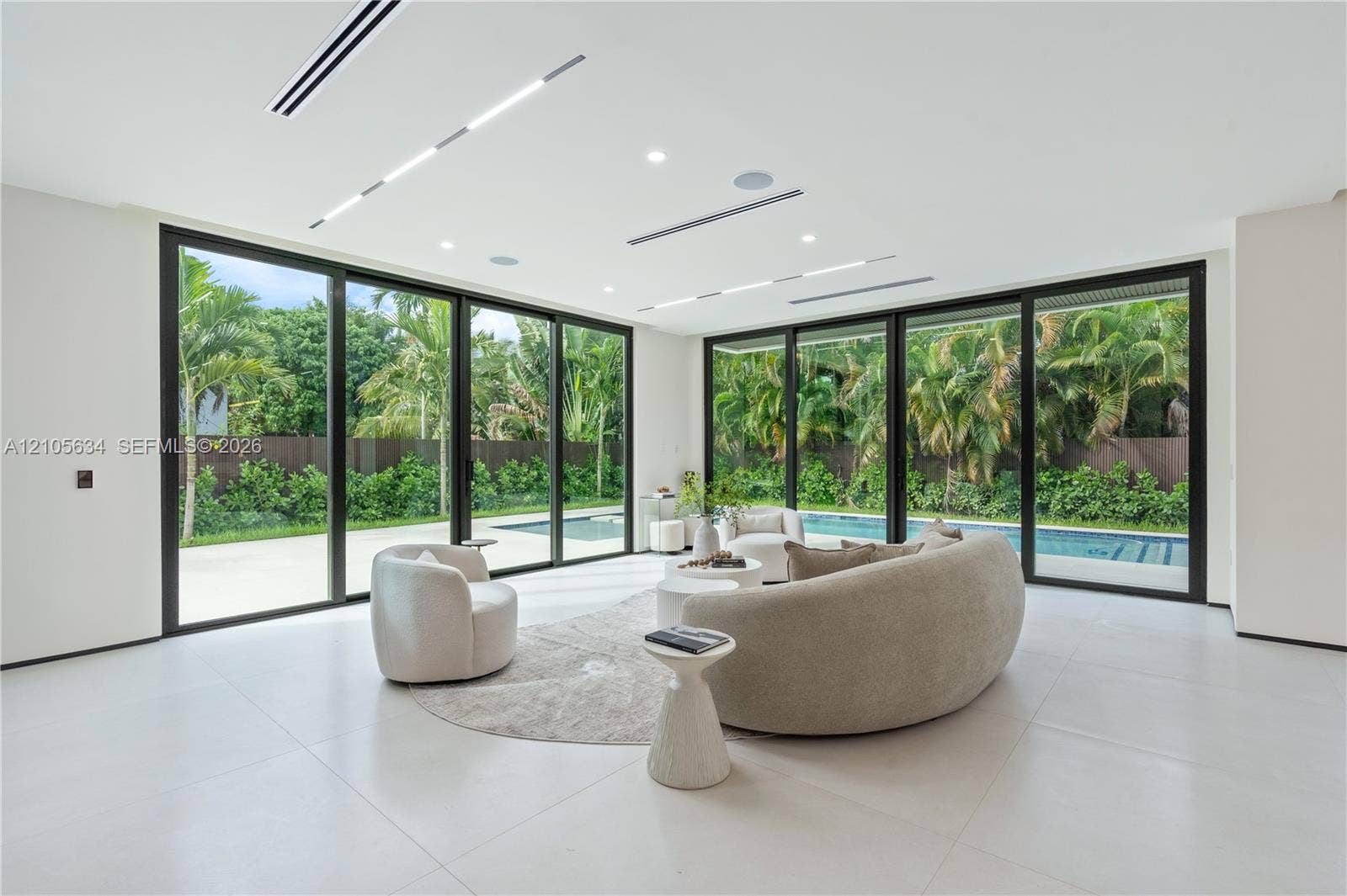 623 NE 16th Terrace, Fort Lauderdale, FL 33304 Large-format sliding glass doors, polished porcelain flooring, recessed linear lighting, built-in ceiling speakers, and perimeter patio access