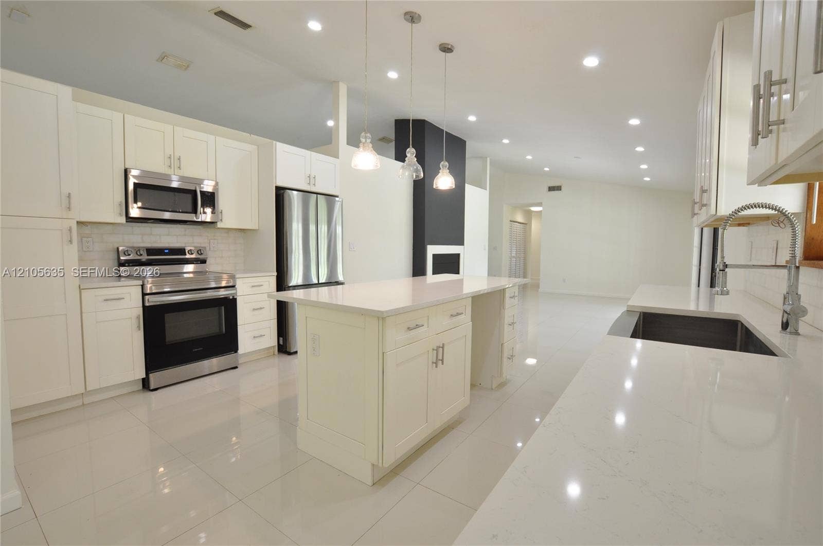 16760 SW 280th Street, Homestead, FL 33031 Kitchen featuring white Shaker-style cabinetry, quartz countertops, a central island, stainless steel appliances, and tile flooring
