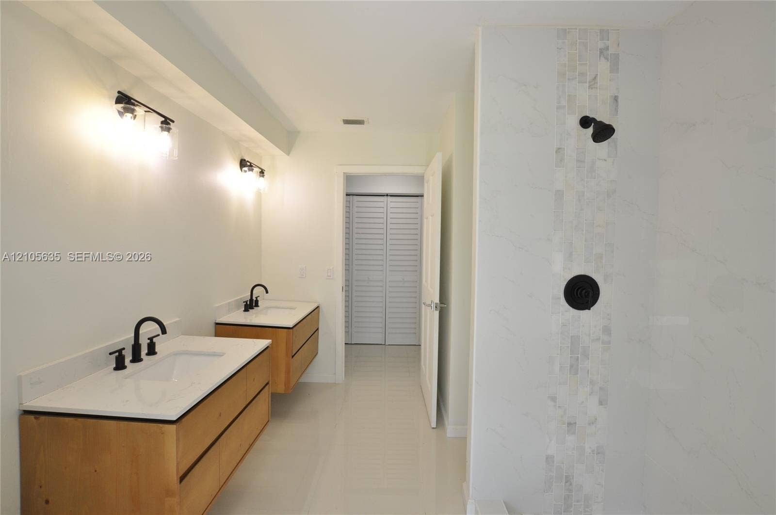 16760 SW 280th Street, Homestead, FL 33031 Dual floating wood-finish vanities with rectangular integrated sinks, white quartz countertops, matte black plumbing fixtures, and a glass-enclosed shower featuring a vertical mosaic stone inlay