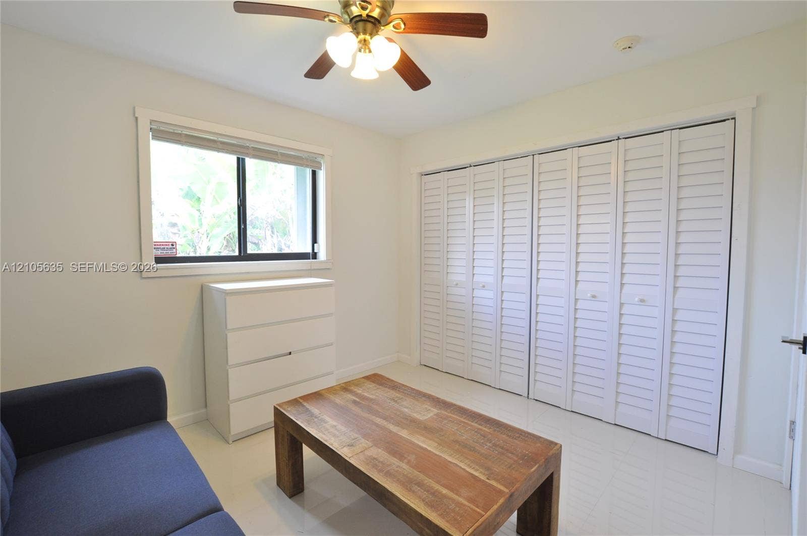 16760 SW 280th Street, Homestead, FL 33031 Room featuring white shutter-style closet doors, a ceiling fan with integrated lighting, a dual-pane window, and high-gloss tile flooring